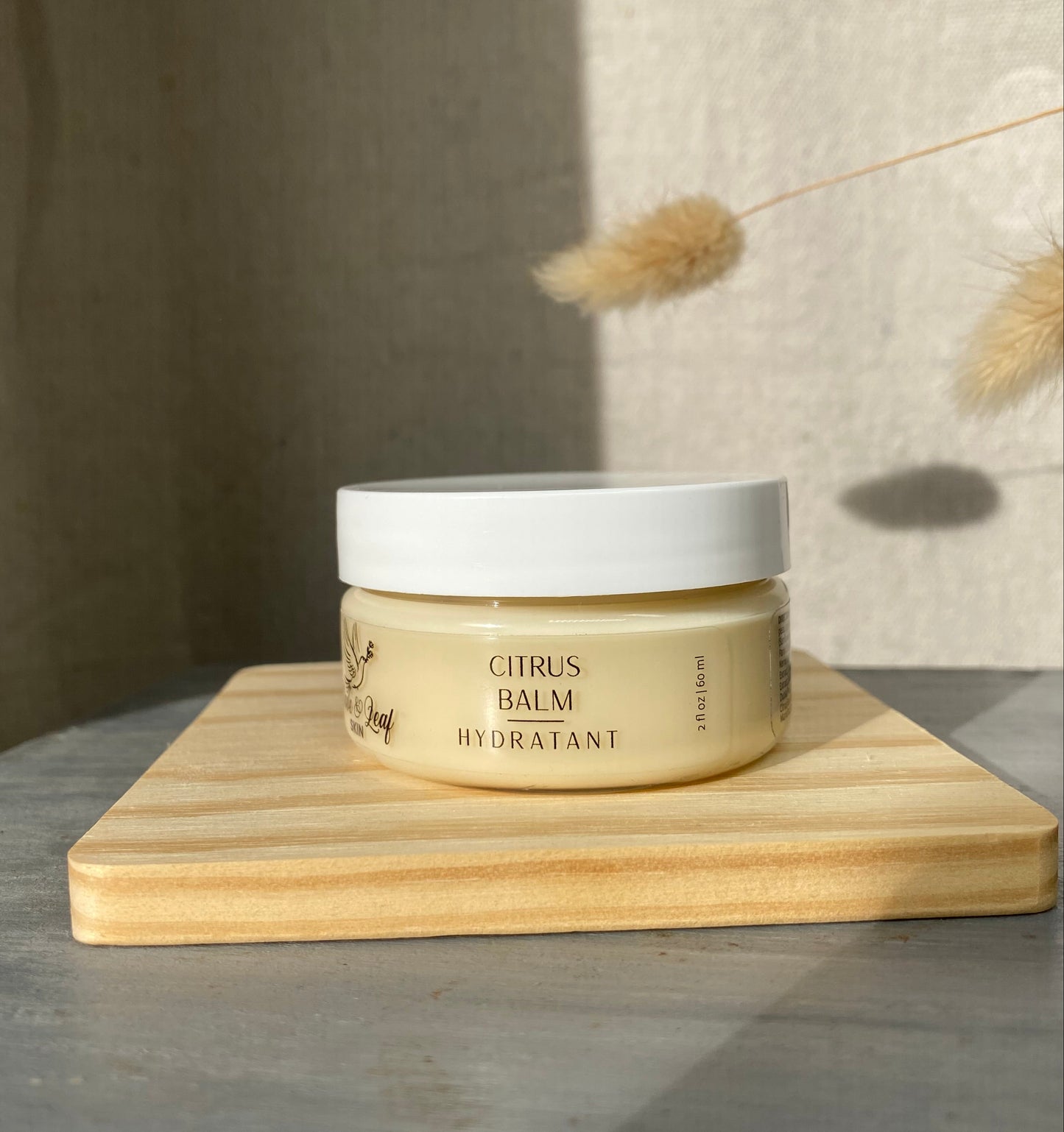 Cosmetic jar on a wooden block with a neutral background