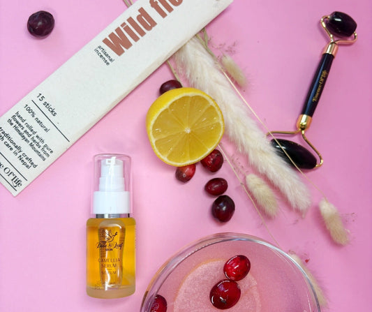 Wild Flora product with a lemon, cherries, and a roller on a pink background