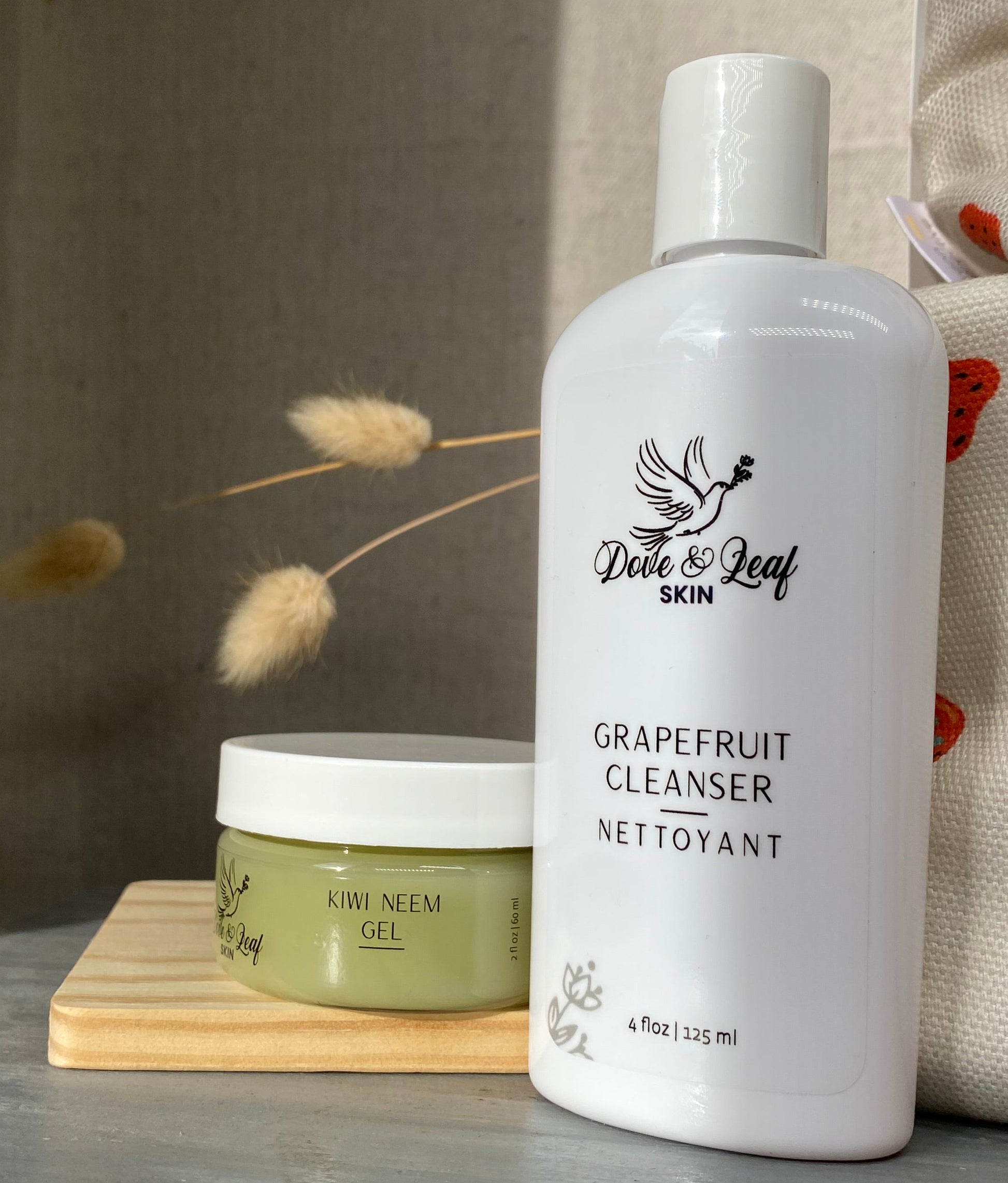 White bottle of grapefruit cleanser on a wooden block with a neutral background