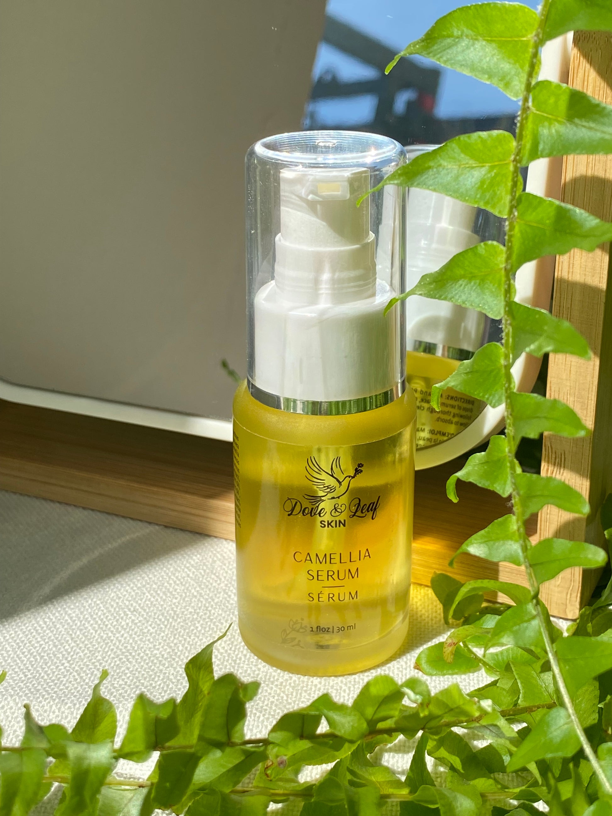 serum bottles, one yellow and one clear, with green leaves in the background.