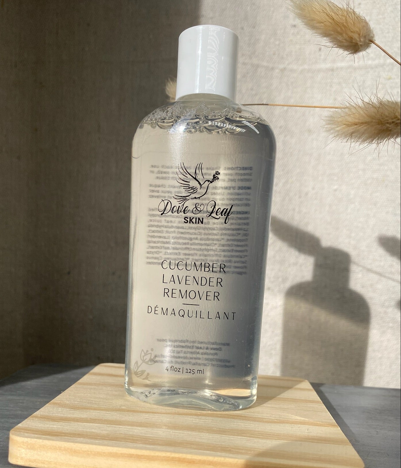 Bottle of cucumber lavender remover on a wooden board with a neutral background